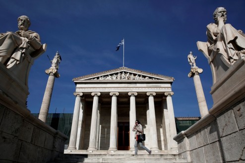 A woman walks in front of the Academy of Athens April 9, 2014. Greece, at risk of crashing out of the euro zone just two years ago, will issue its first sovereign bond in almost four years on Thursday, seeking to send a strong political and economic signal it is on the way out of its debt crisis. REUTERS/Yorgos Karahalis (GREECE - Tags: POLITICS BUSINESS SCIENCE TECHNOLOGY TRAVEL) - RTR3KKWL
